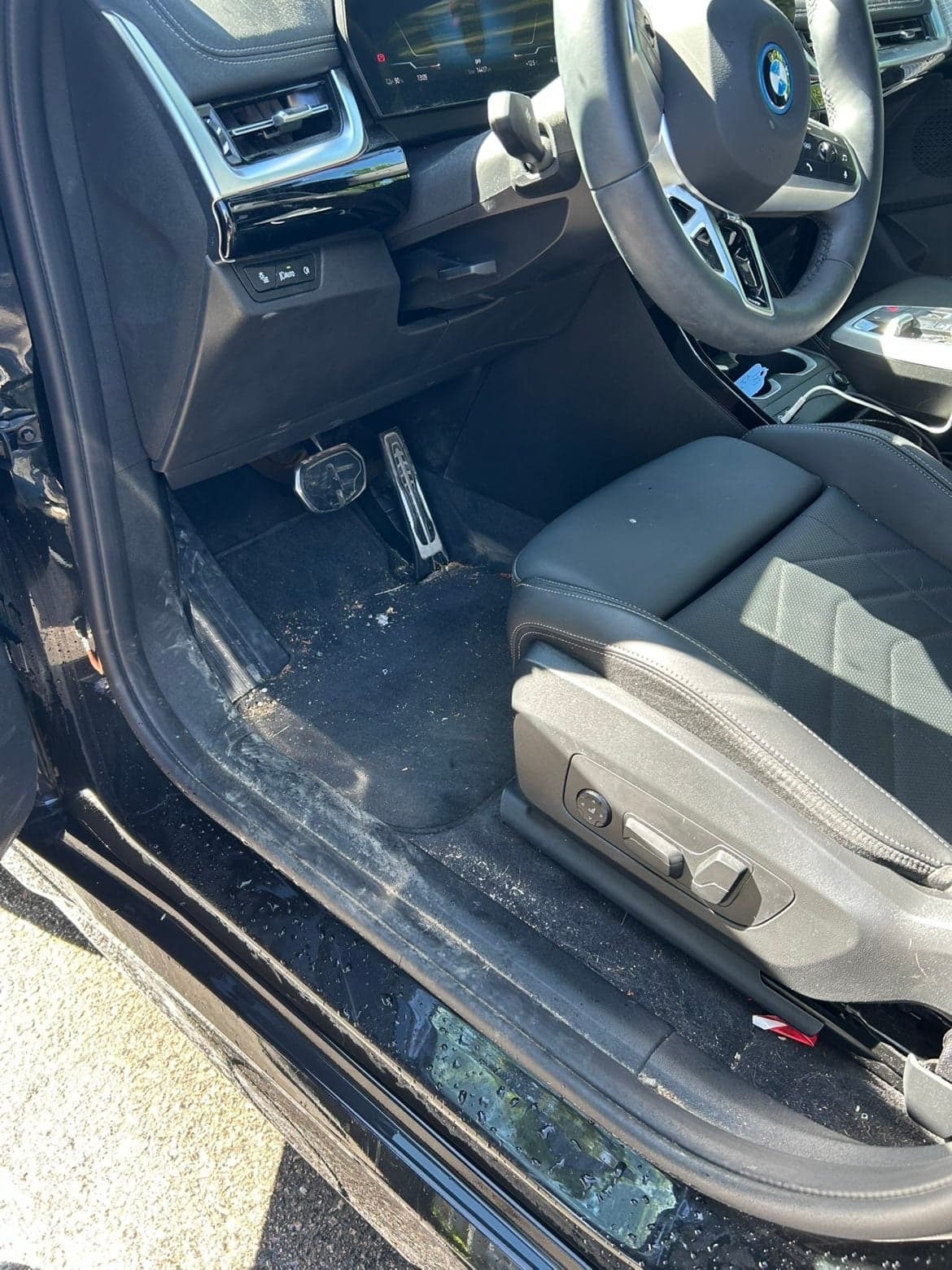 BMW iX1, fotbrønn og dørkarm med grus og støv før rens